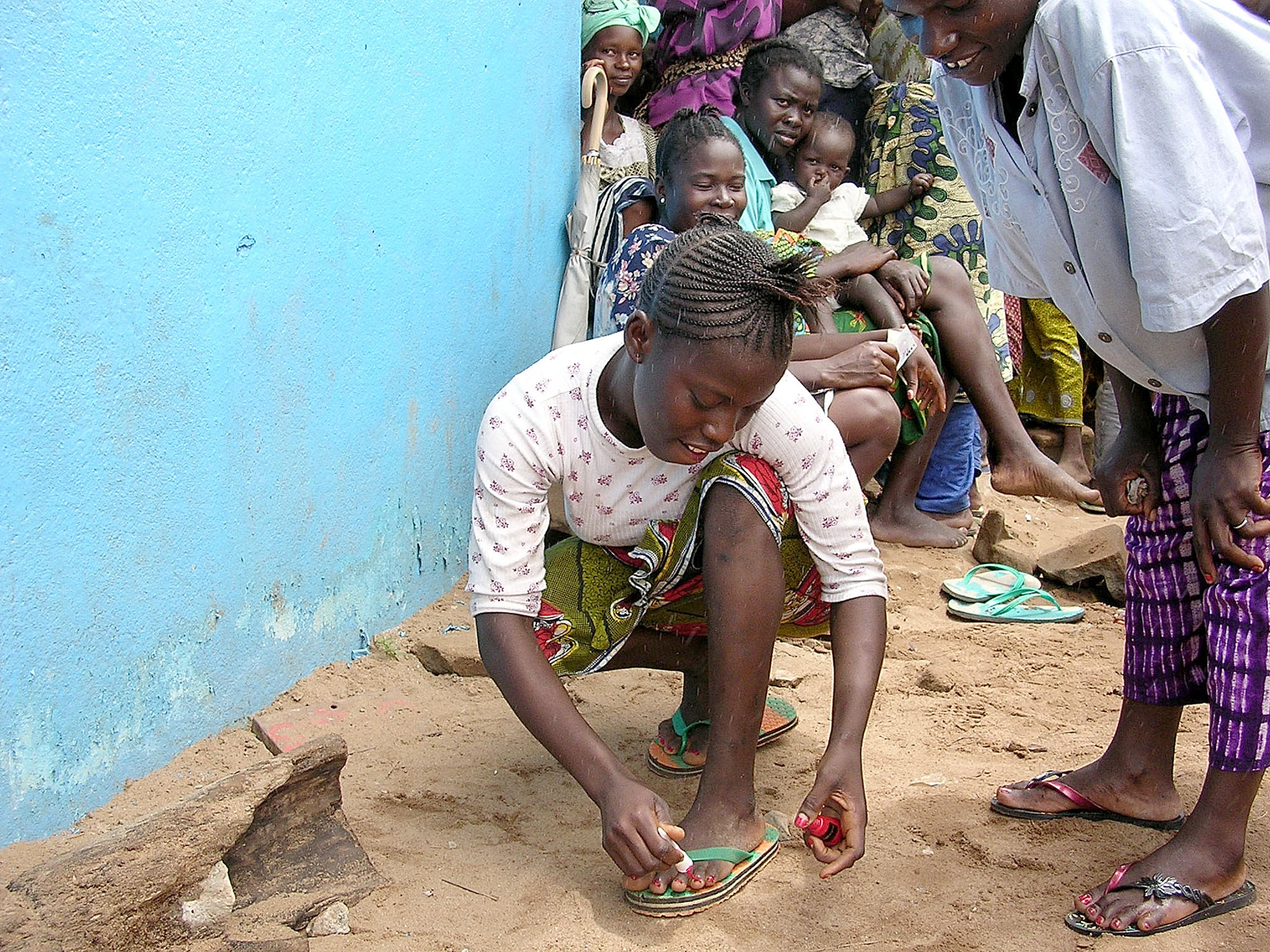A young girl paints her toenails at a camp for displaced persons at the Samuel Doe Sports Complex in Monrovia, Liberia. As peace takes hold in this West African capital, United Methodist teams are busy trying to identify the needs of a people whose country has been ravaged by war. A UMNS photo by Joni Goheen.
