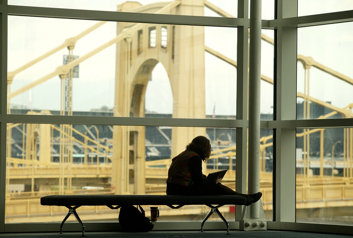 Katy Hinman, a member of the General Conference Choir from Candler School of Theology, finds a quiet spot to study her music in Pittsburgh's David L. Lawrence Convention Center, site of the 2004 General Conference. In the background is the 9th Street Bridge over the Allegheny River. A UMNS photo by Mike DuBose.