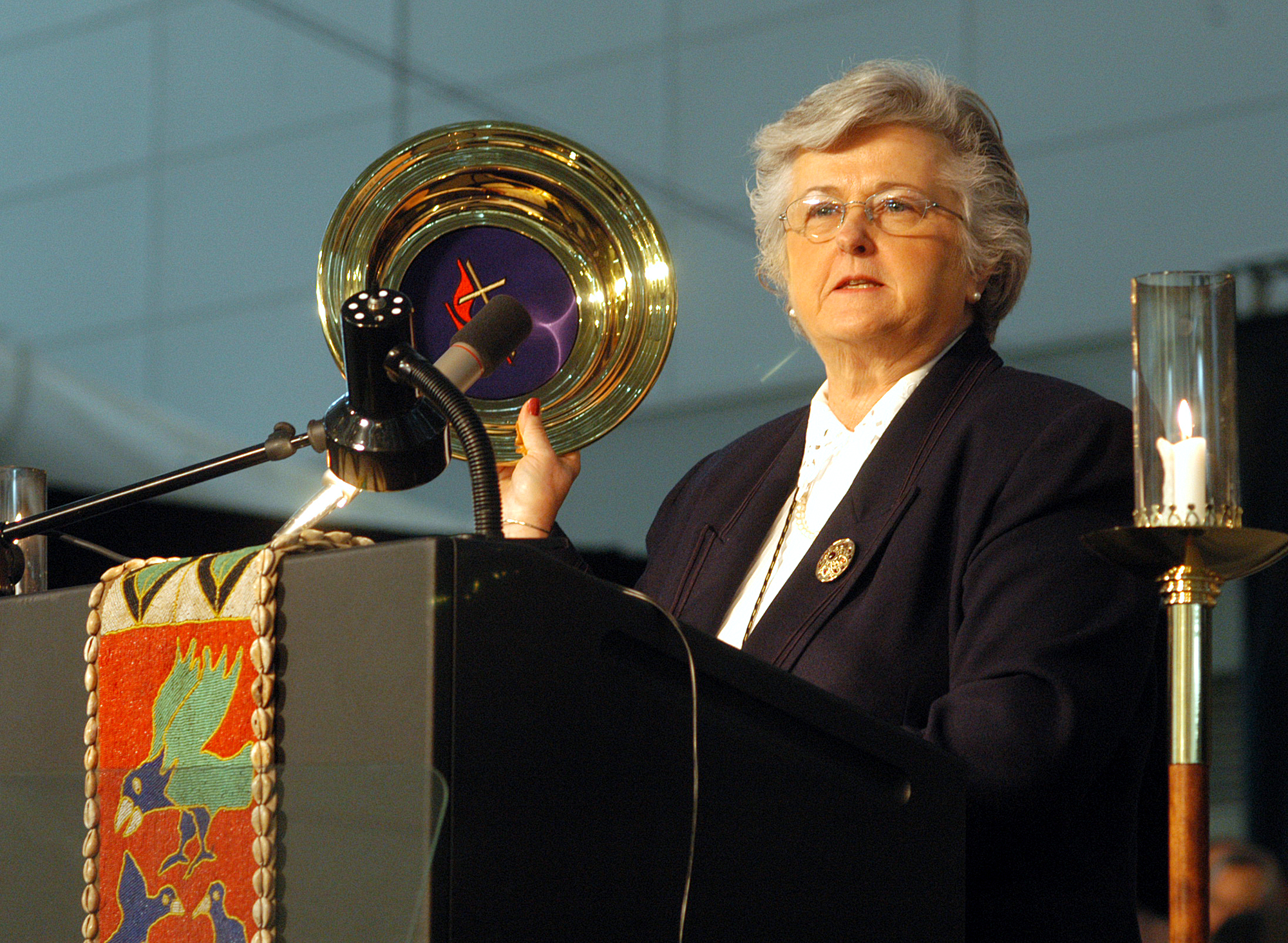 Sandra Kelley Lackore, top staff executive of the United Methodist Church's General Council on Finance and Administration, uses a church offering plate to emphasize the resources for mission and ministry as she discusses the financial state of the church during the denomination's 2004 General Conference in Pittsburgh. A UMNS photo by John C. Goodwin.