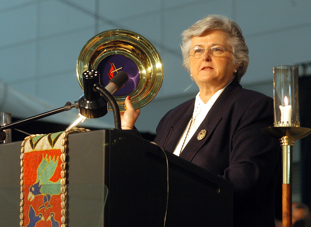 Sandra Kelley Lackore, top staff executive of the United Methodist Church's General Council on Finance and Administration, uses a church offering plate to emphasize the resources for mission and ministry as she discusses the financial state of the church during the denomination's 2004 General Conference in Pittsburgh. A UMNS photo by John C. Goodwin.