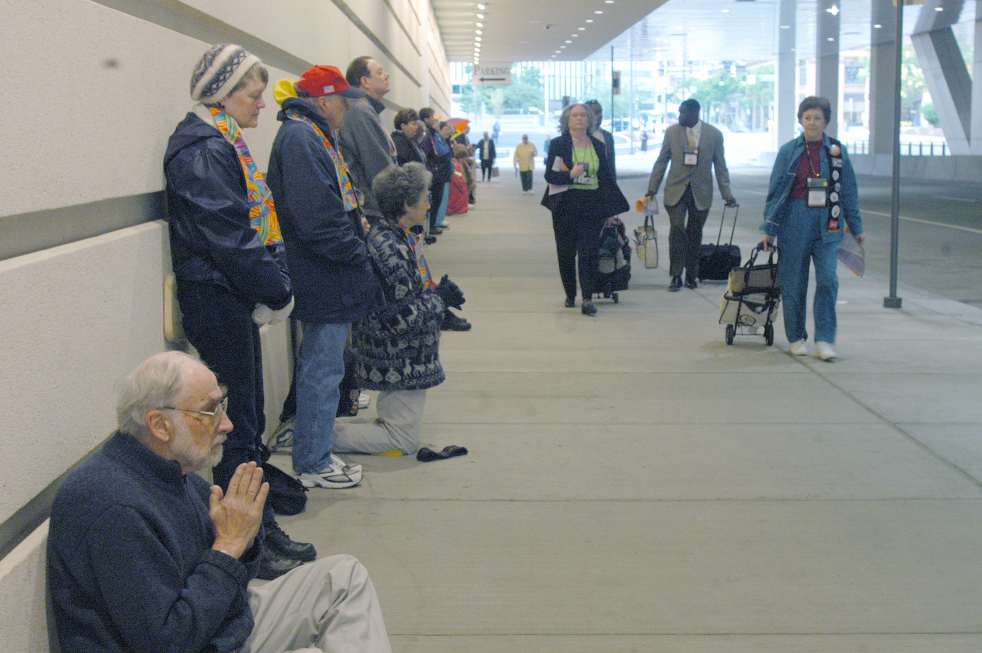 The Rev. John Collins (left) prays in silent witness in support of changing the denomination's stance on homosexuality while delegates to the church's 2004 General Conference file into the David L. Lawrence Convention Center. Collins is retired from the New York Annual Conference. A UMNS photo by John C. Gopodwin.