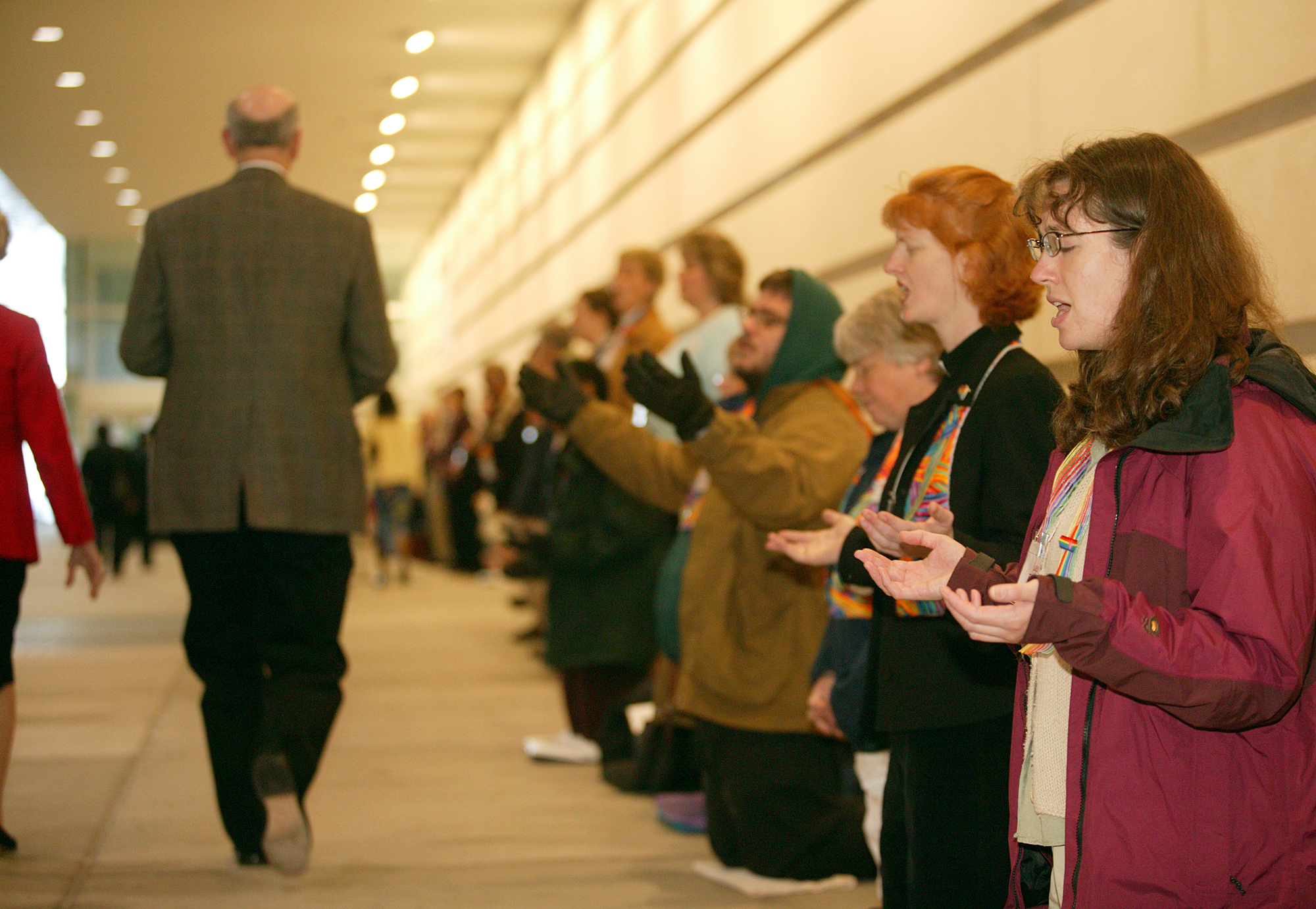 Laura Folkwein (right) and Elizabeth Brick (second from right) pray during a protest at General Conference. A UMNS photo by Mike DuBose.