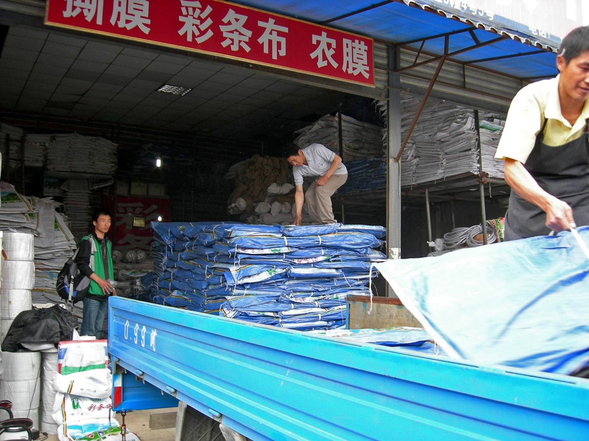 Yue Yaomeng (left) oversees the loading of tarps that will be distributed by Amity Foundation to earthquake survivors. A UMNS file photo courtesy of Yue Yaomeng.