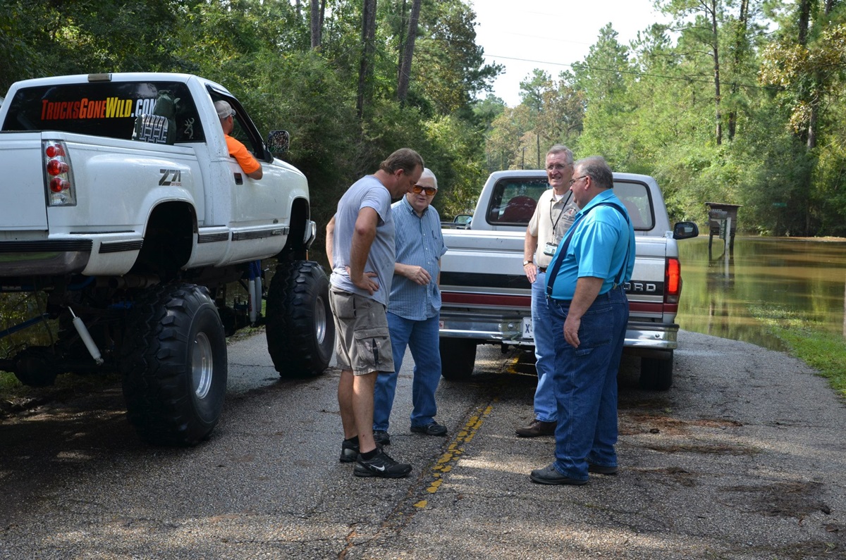 Gene Coumas visits with Milton, Cottrill and Bourque on the flooded road leading to Lee’s Landing United Methodist Church. Coumas in his truck (left) rescued several members of the community trapped by floodwaters.