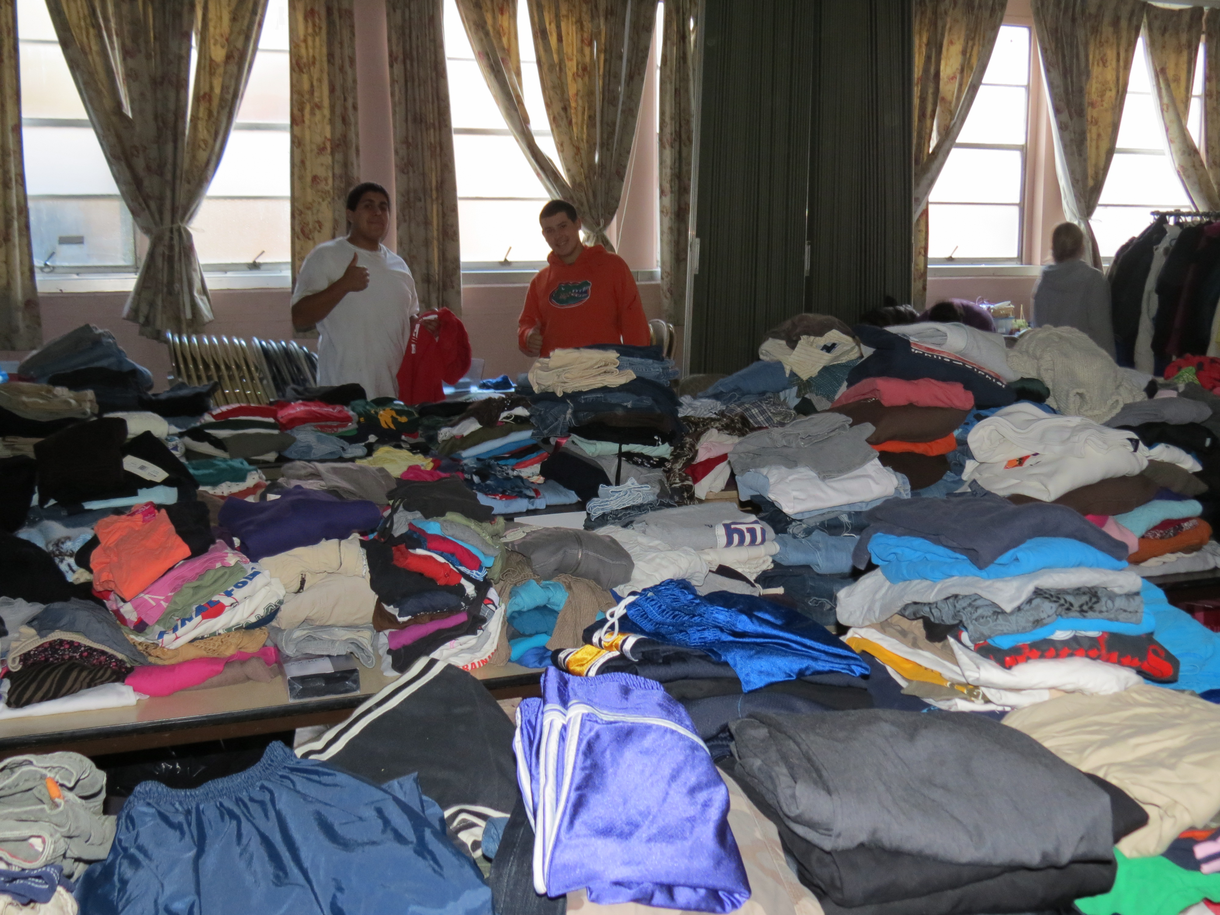 Teen volunteers sorting donated clothing in the dark basement of Grace UMC in Lindenhurst, N.Y.