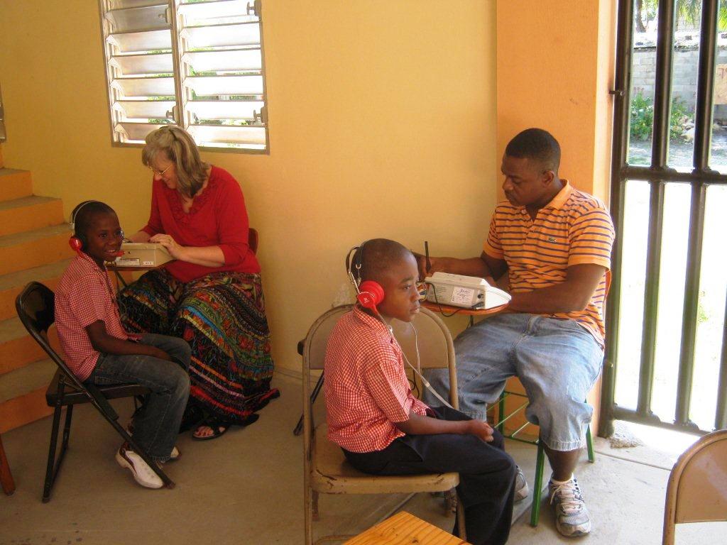Dr. Sally Muhlbach and Dr. Ricardo Gautier test the hearing of Haitian school children. Photo by Gil Hanke