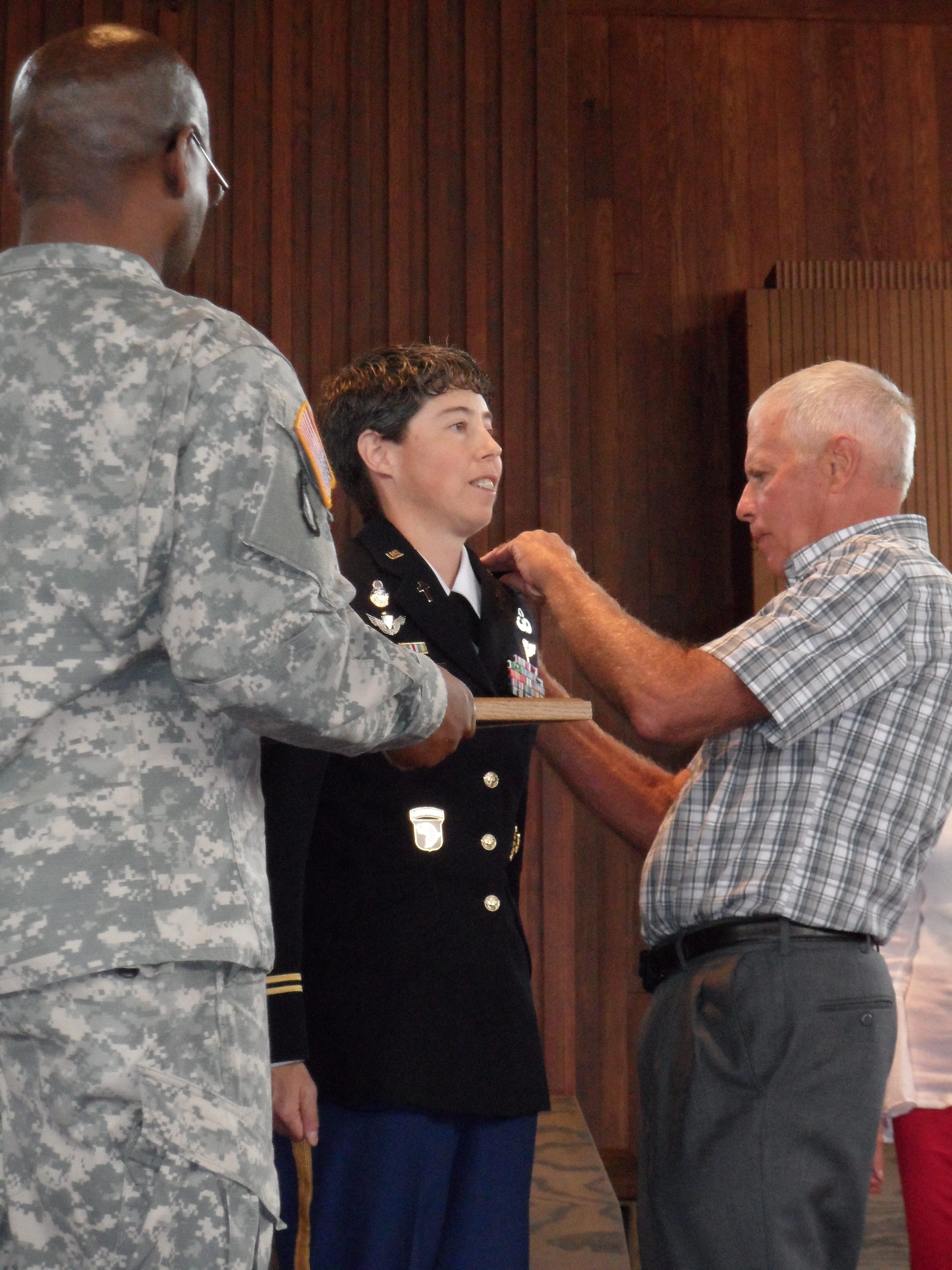 Jim Meeker, Lt. Col. Karen Meeker’s father, places shoulderboard showing her new rank. Photo courtesy of Meeker family.