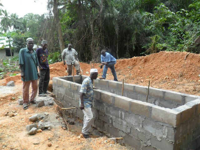 Workers construct new public toilets as part of a church-led community development project in Yonibana, Sierra Leone.