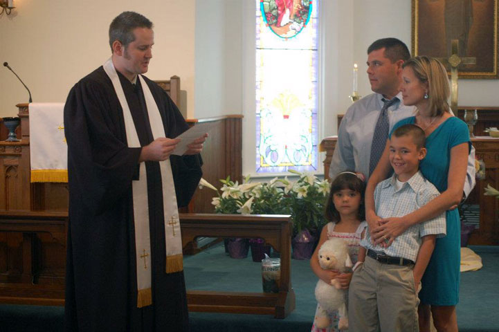 Pastor Russell Clark of the United Methodist Church of Reddick (Fla.) welcomes new members, Lannie and Erin Thompson and their children.