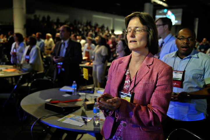 The Rev. Sandra Steiner Ball, now bishop of the West Virginia Episcopal Area, holds a stone as she prays during the Act of Repentance at the 2012 General Conference.