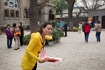 Greeter Wang Yan Na welcomes parishioners and visitors to Chongwenmen Church in Beijing.