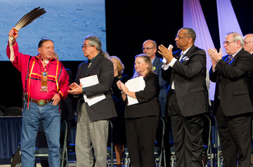 The Rev. George Tinker (left) receives the applause of United Methodist Church leaders after giving the sermon at the 2012 United Methodist General Conference in Tampa, Fla.  Applauding Tinker (from left, front row) are: the Rev. Thom White Wolf Fassett and Bishops Mary Ann Swenson, Robert E. Hayes Jr. and Larry M. Goodpaster. A UMNS photo by Mike DuBose.