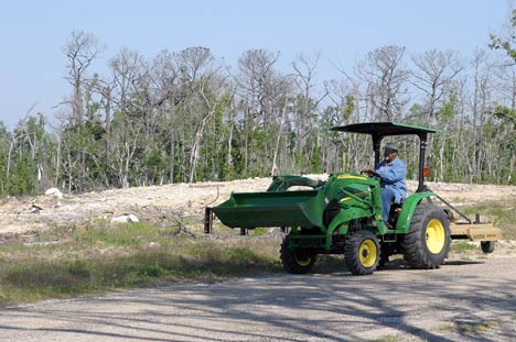Abraham Carey drives a tractor across the grounds of Gulfside Assembly. More than 20 months after Hurricane Katrina destroyed the historic United Methodist facility, debris still litters the area. A UMNS photo by Kathy L. Gilbert.