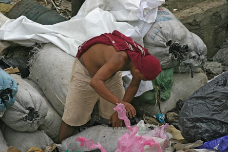A man searches through bags of garbage for recyclables to resell in the Payatas landfill in Manila, Philippines. The island nation's capital city is one of the most densely populated places on earth. 