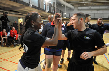 (From left) An army coach and player celebrate victory following a volleyball game played in recognition of Warrior Care Month. A UMNS photo by Jay Mallin.