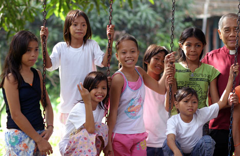 Bishop Solito K. Toquero (far right) visits with some of the young girls living at the Gilead Center, a residential shelter for street children supported by The United Methodist Church.