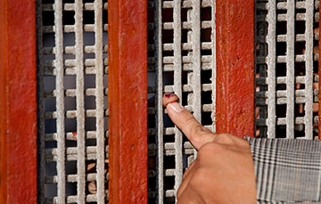 Tightly-spaced wire mesh prevents more than fingertip contact across the border between Tijuana, Mexico, and the U.S.