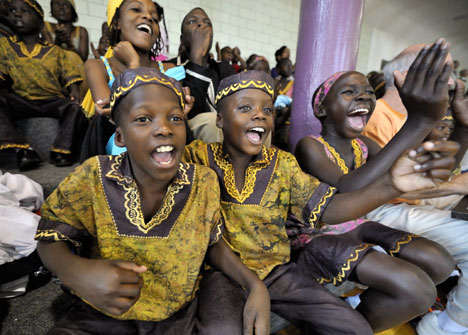 Members of a Ugandan children’s choir cheer during a fundraising basketball
game. The children (from left) are Ronald Kabubi, 10; Tonny Kyembe, 8; and
Winnifred Acibo, 11.  