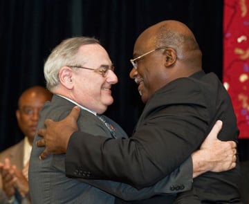 Bishops Goodpaster and Palmer embrace following the passing of the gavel. A UMNS photo by James D. DeCamp.