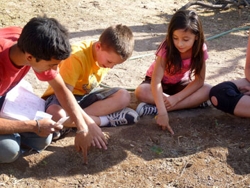 Students from the after-school garden class at Davis Elementary plant with André Luiz de Oliveira Domingues. Photo courtesy of Julie Diaz.