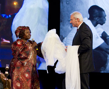 Here Gbanga and Bishop Thomas J. Bickerton hold an insecticide-treated mosquito net during a celebration of the work of the Imagine No Malaria campaign during the 2012 United Methodist General Conference in Tampa, Fla. A UMNS photo by Mike DuBose.
