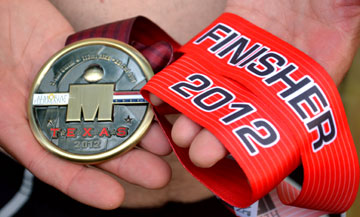 The Rev. Sharp displays the medal he achieved after finishing the grueling Ironman race in The Woodlands, Texas, on May 19, 2012. Photo courtesy of the Rev. Scott Sharp.