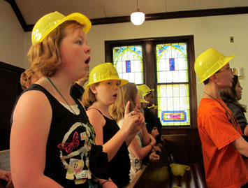 Singing while wearing hardhats goes with the theme of 