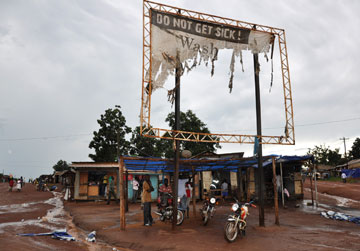 A torn billboard in the Yei District of South Sudan informs passersby of health alerts.
