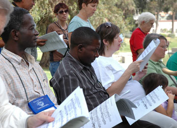 The Rev. Baamu Moses of Uganda, left, and the Rev. Copeland Nkhata from Malawi join others at the closing Shalom Summit worship service and lunch in L.A.'s MacArthur Park. A UMNS photo by Cate Monaghan.