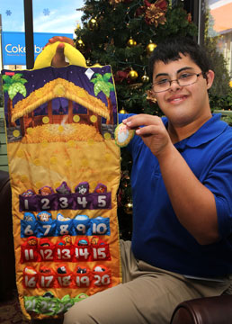 Store visitor, Andrew Donaldson, shows how to use a special holiday item offered by Cokesbury  a Fisher-Price Advent Calendar made of fabric.  Donaldson visits Cokesbury weekly through a community-based transition program.