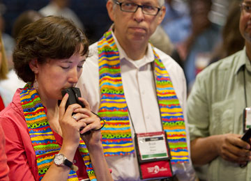 Delegate Sara Ann Swenson (left) of Minnesota presses her voting keypad to her lips while awaiting results of a vote on the United Methodist Church's stance on sexuality. A UMNS photo by Mike DuBose.