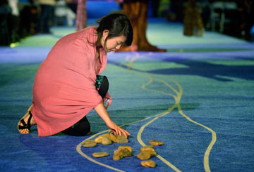 A delegate picks up a stone in the aisle during the Act of Repentance at the 2012 General Conference in Tampa, Fla. A UMNS photo by Paul Jeffrey.