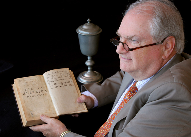 Robert J. Williams is retiring as top executive of the Commission on Archives and History. He’s shown here holding a Bible and wearing glasses owned by Francis Asbury and with a communion chalice used by Philip William Otterbein. Asbury and Otterbein are important early figures in Methodist history.  A UMNS photo by Kathleen Barry