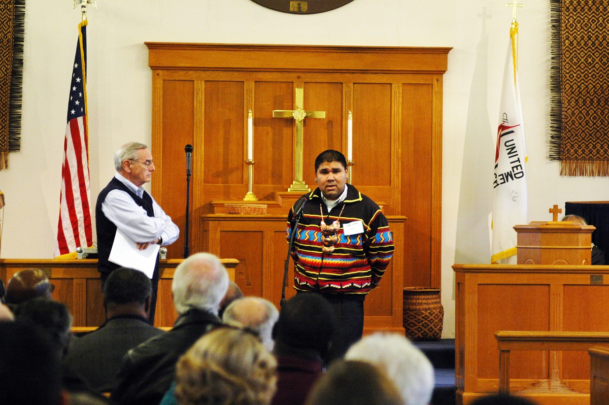 The Rev. Glen Chebon Kernell, executive secretary for the Native American and Indigenous Ministries at the United Methodist Board of Global Ministries, speaks to visiting members of the Council of Bishops at Cherokee United Methodist Church. At left is Bishop Larry Goodpaster. UMNS photos by Annette Spence.