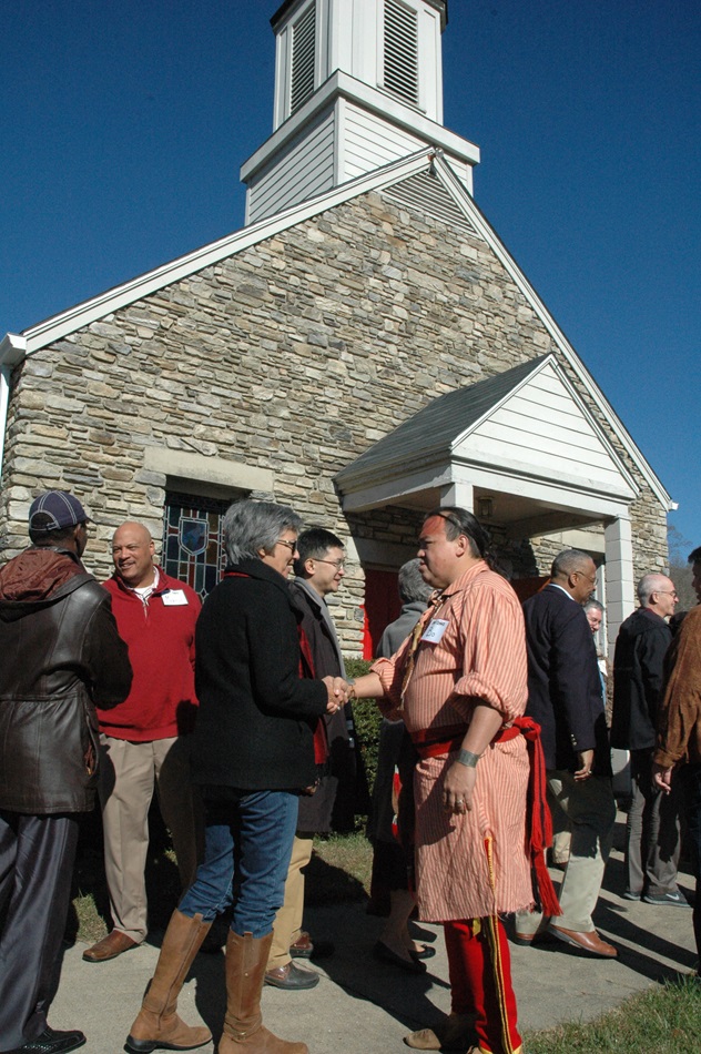 Bishop Hope Morgan Ward of the Raleigh Area is greeted by Bo Taylor (dressed in Native American clothing) as bishops arrive at Cherokee United Methodist Church on Nov. 13. A UMNS photo by Annette Spence.