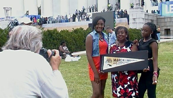 Edith Lee-Payne (holding banner) poses with her granddaughters Destiny (left) and Dejai during the 50th anniversary of the March on Washington. Making their family portrait is Rowland Scherman, who made an iconic photograph of Edith during the 1963 march.