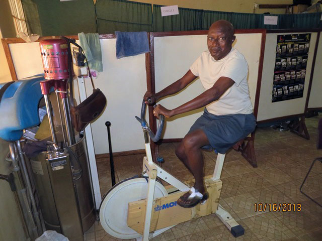 The Rev. Steven Momoh Momo-Jah, a United Methodist pastor, works on physical exercise at the physical therapy unit. Photo by Phileas Jusu, UMNS.