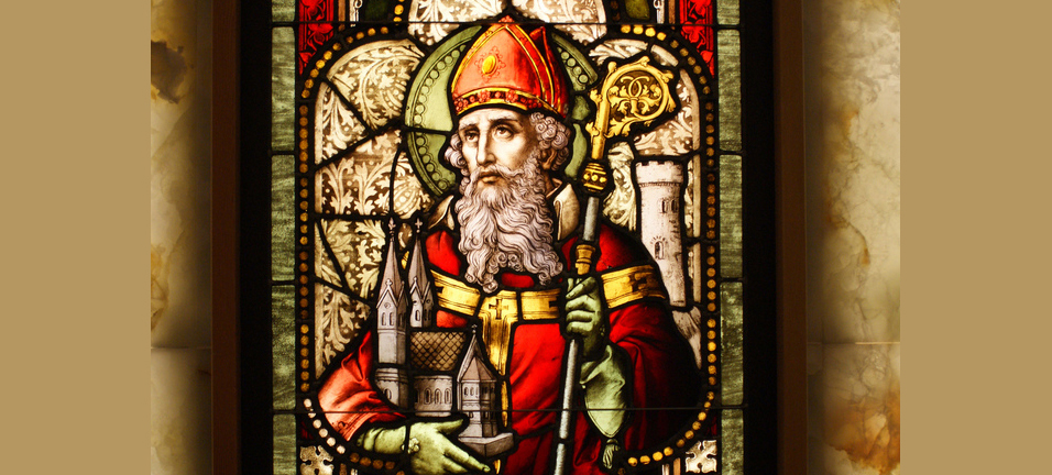 A stained-glass window in the United States depicts St. Patrick with his staff and holding a church. 
