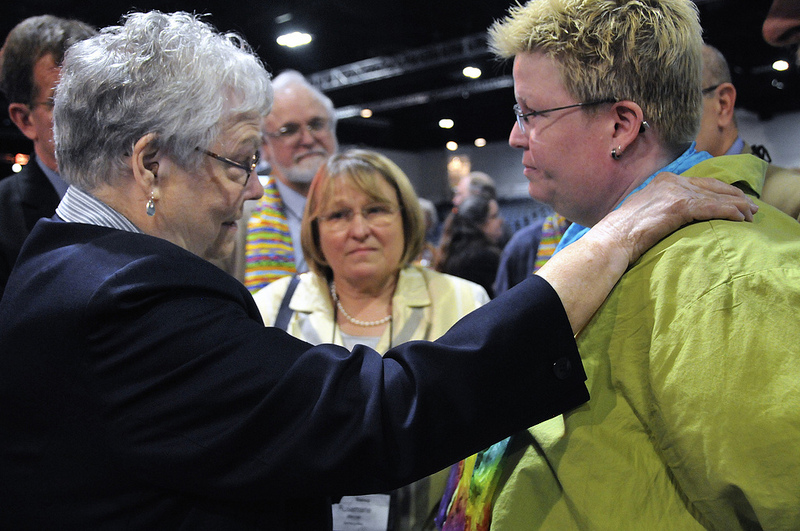 Bishops Judith Craig (left), Scott Jones (behind Craig) and Rosemarie Wenner (center) negotiate with the Rev. Amy DeLong, after dozens of demonstrators demanding a more inclusive church took over the floor of a May 3 session of the 2012 United Methodist General Conference in Tampa, Fla. The three bishops talked with DeLong in an attempt to resolve the situation without resorting to arrests.