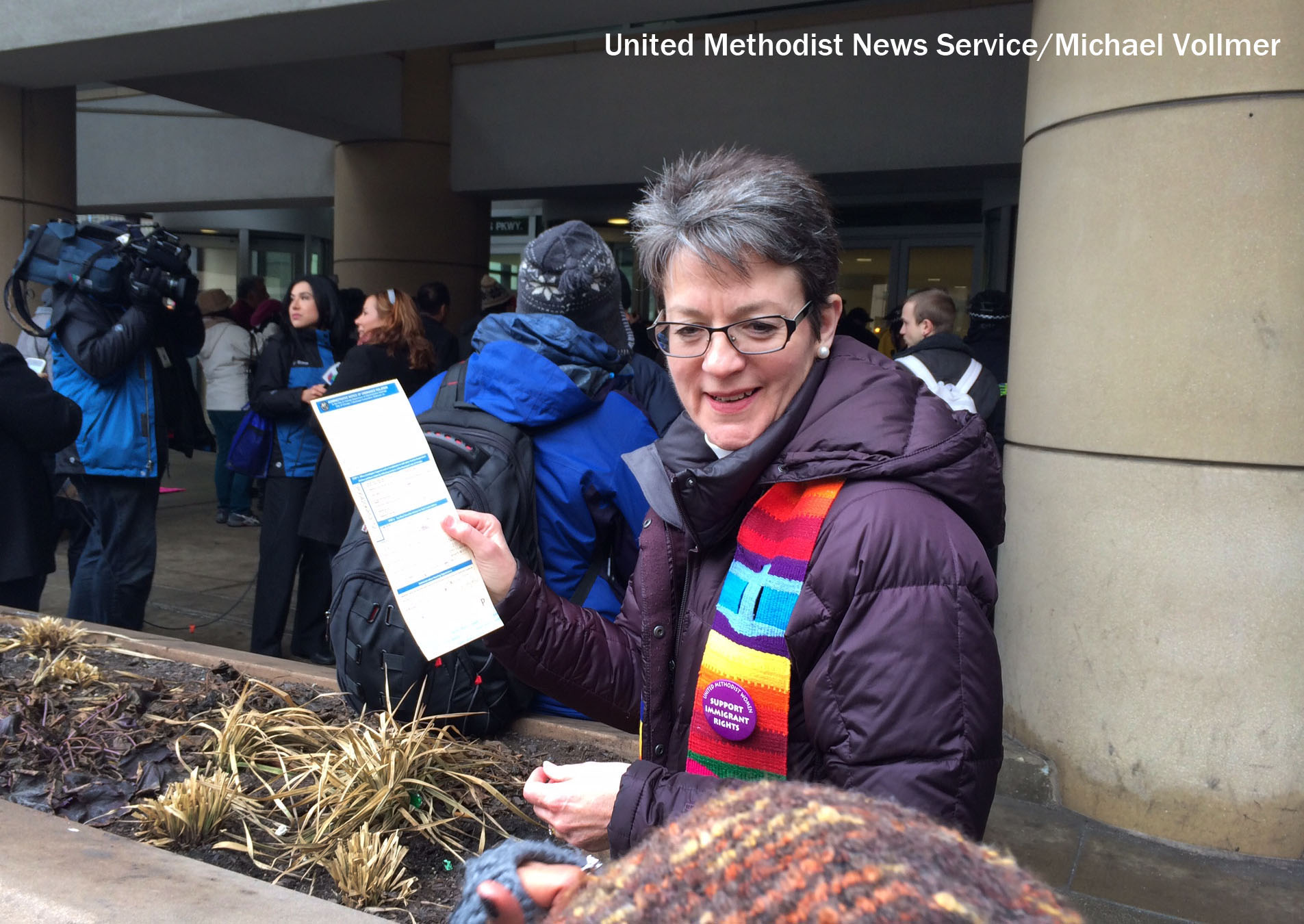 United Methodist Bishop Sally Dyck, Chicago holds a citation for criminal trepassing outside the ICE office. The citation followed the rally and protest calling upon President Obama to stop deportations of undocumented people. Photo by Michael Vollmer, UMNS.
