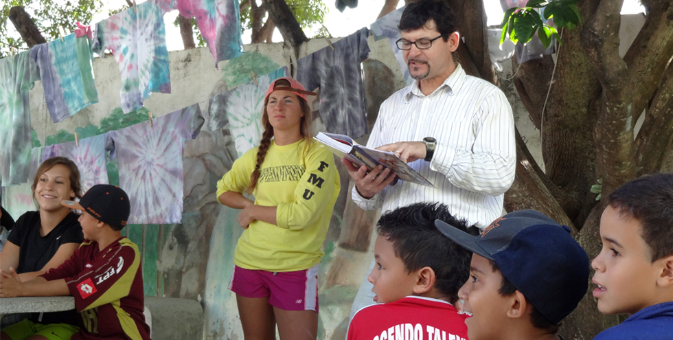 Phil Wingeier-Rayo, professor of religion at Pfeiffer University, reads the Bible to children in a vacation Bible school class during a Pfeiffer University mission trip to Brazil in June 2013. Photo by Diana Wingeier-Rayo.