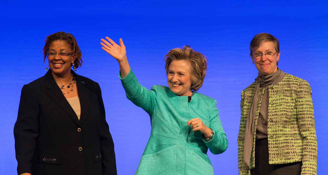 Hillary Rodham Clinton (center) waves to participants at the United Methodist Women's Assembly at the Kentucky International Convention Center in Louisville, Ky., following her address to the group. She is flanked by Yvette Richards (left) and Harriett Jane Olson of United Methodist Women.