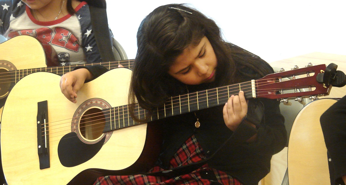 Isabella Barco, 7, practices a D chord in guitar class at Christ’s Foundry United Methodist Church in Dallas.