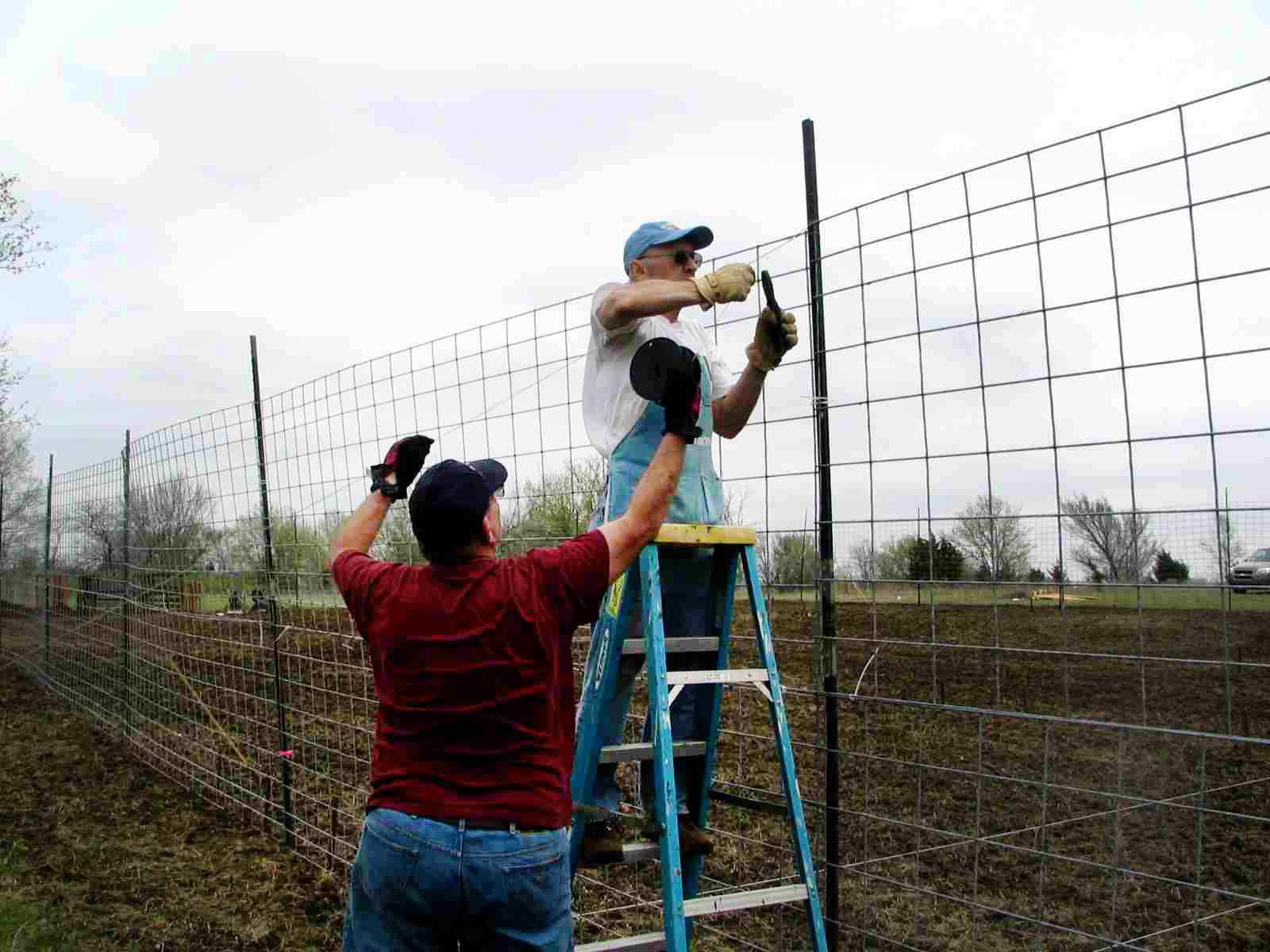 Volunteers with Bartlesville First Church prepare the fencing for their community garden in order to “keep the critters out.” The project started as a 2009 Change the World project.