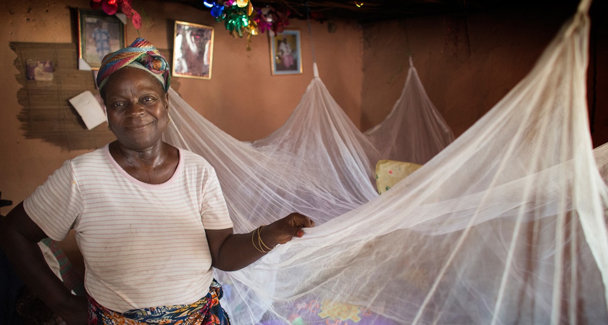 Matilda Ndanema displays the insecticide-treated mosquito net she received in 2010 from the United Methodist Church's Imagine No Malaria campaign at her home in Bumpe, Sierra Leone.