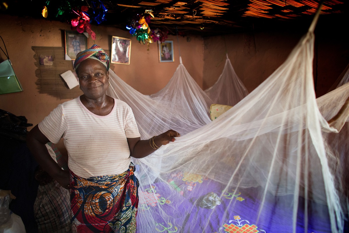 Matilda Ndanema displays the insecticide-treated mosquito net she received from the United Methodist Church's Imagine No Malaria campaign at her home in Bumpe, Sierra Leone. Photo by Mike DuBose, UMNS.