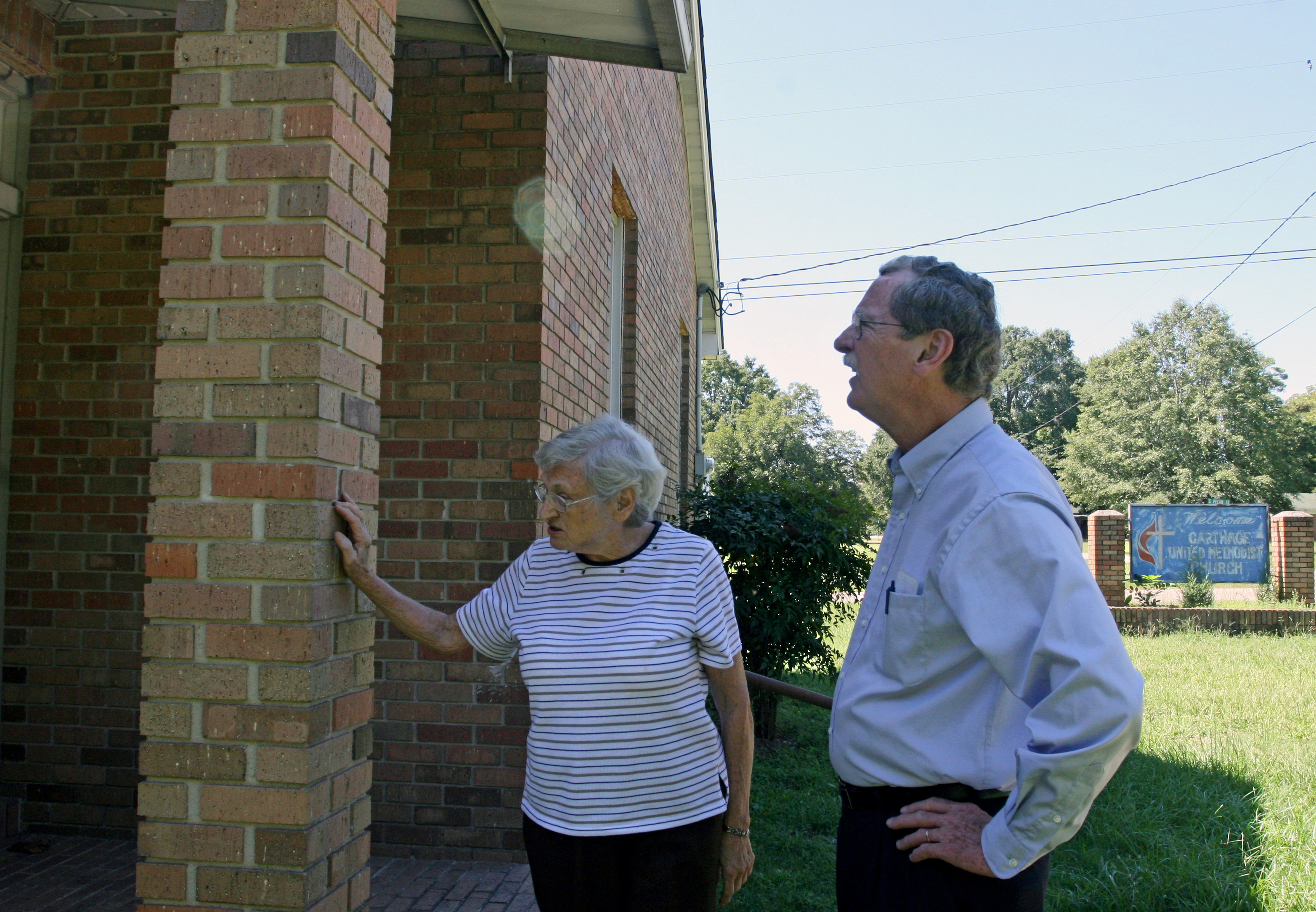 Ida Mae Nutt, the last surviving member of Carthage United Methodist Church, shows the Rev. James Batts some water damage on the brick building. The members of the four churches in the Carthage charge talked about closing the church earlier this year, but Nutt and the others decided to keep the building open for worship once a month. Nutt, with help from Matthews, takes care of the building. Photo by Heather Hahn, UMNS.