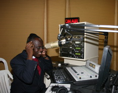 Bishop Boni tries out the equipment at the new station, 'The Voice of Hope.'