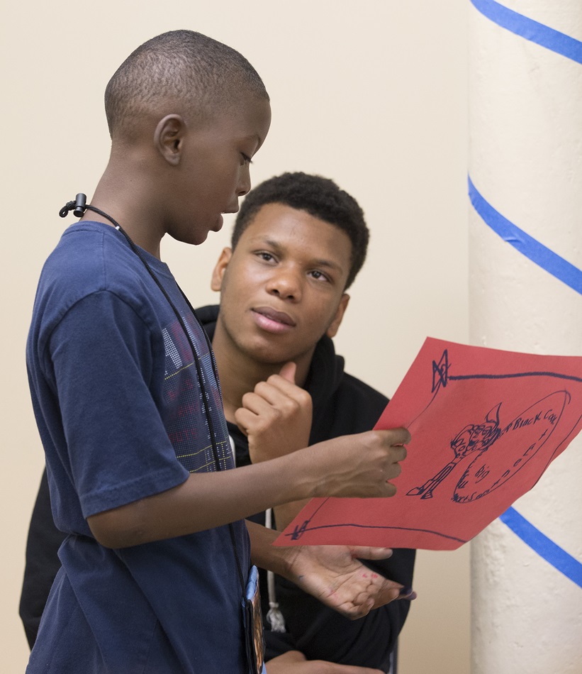 Teen volunteer Tra'Sean, right, encourages 6th-grader J.B. to explain his drawing at the Freedom School at Gordon Memorial United Methodist Church in Nashville, Tenn. 