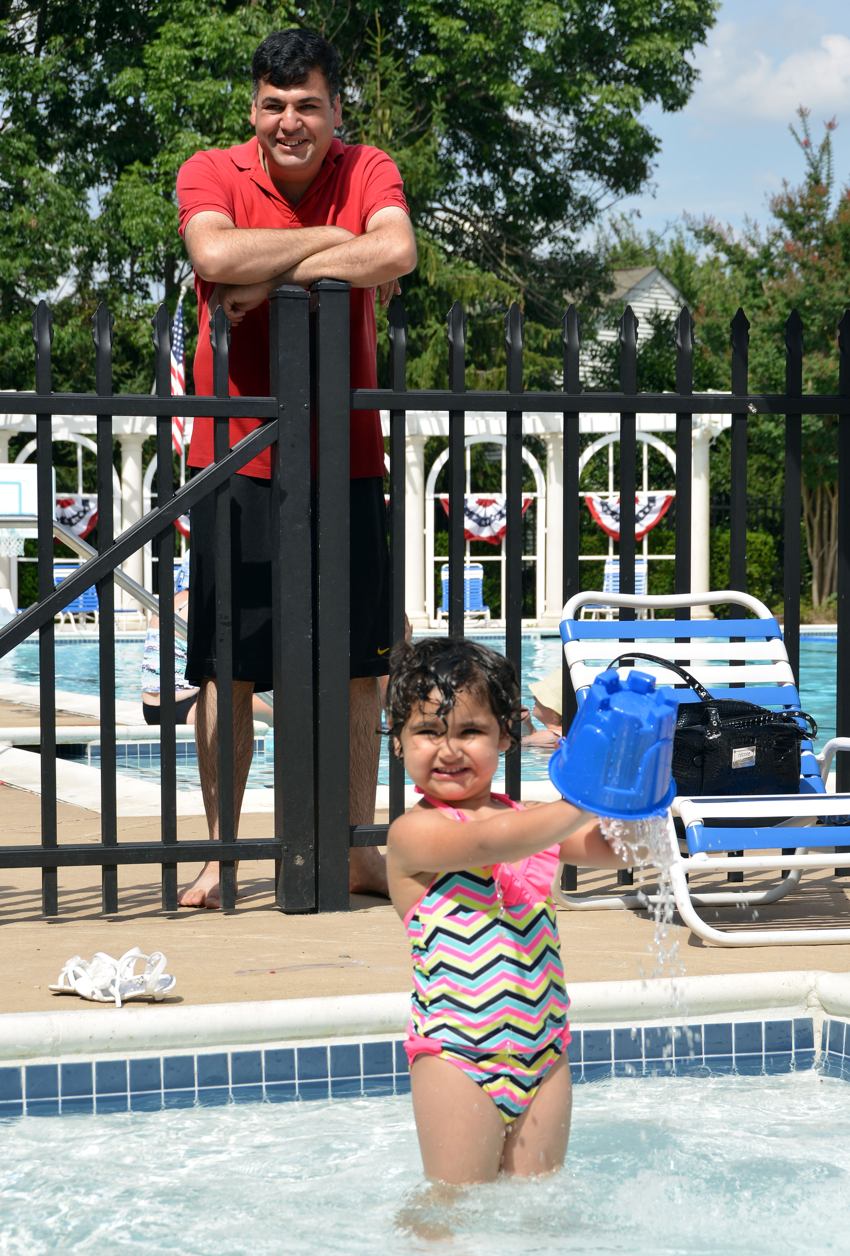 Hameed watches as his dauther, Zala, 3, swims in a pool for the first time. 